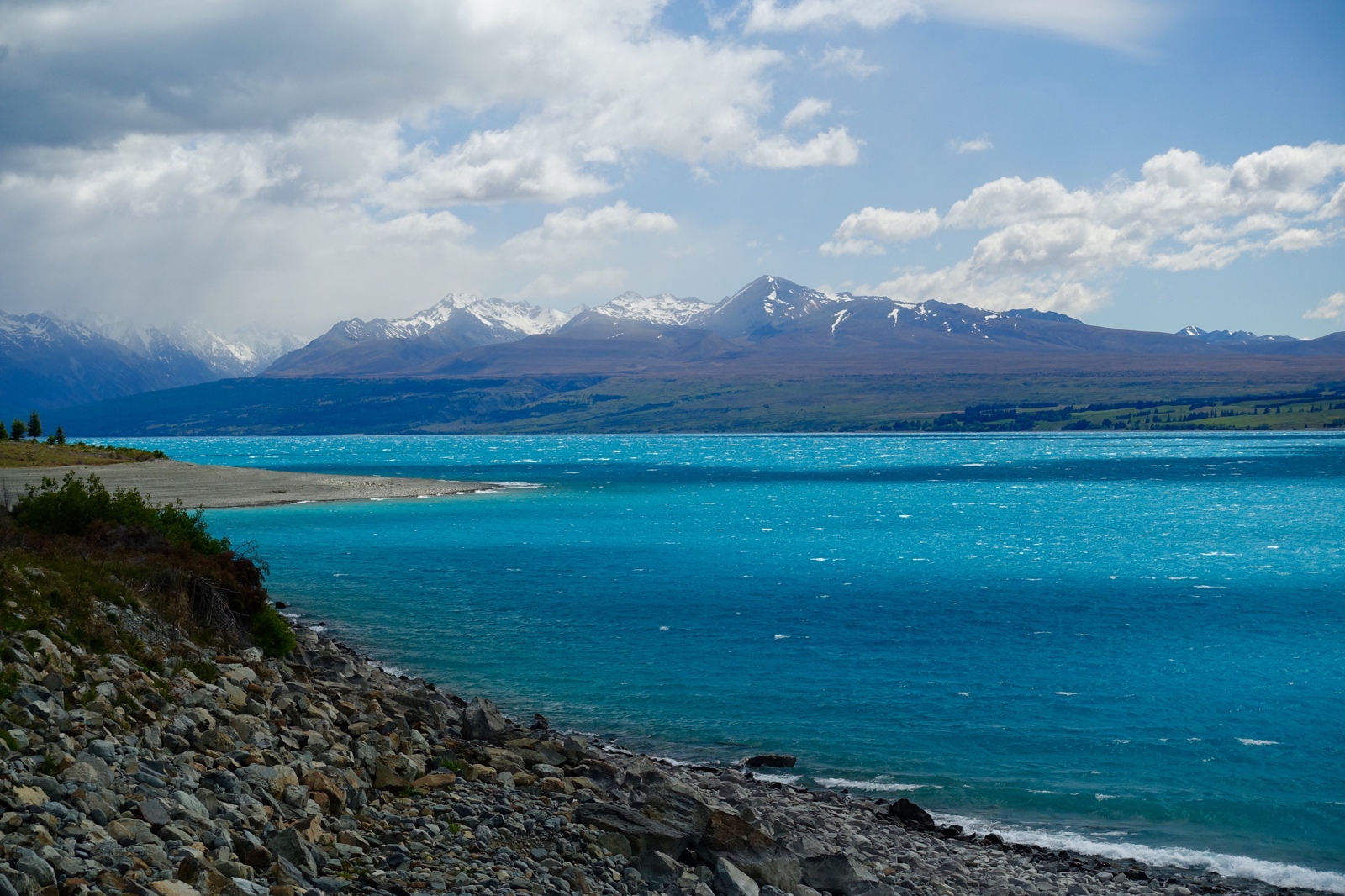 The clouds lifted for a bit and we caught a glimpse of the mountains behind the beautiful blue Lake Pukaki.