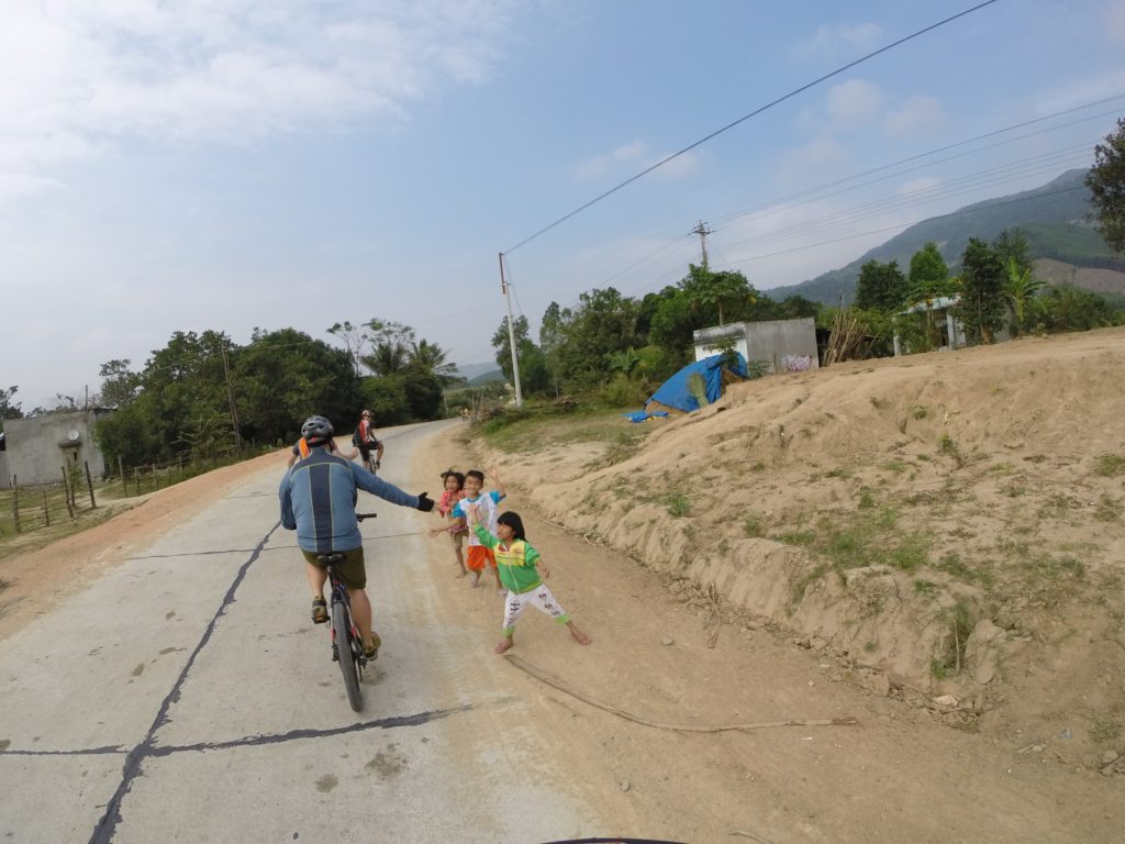 Glenn giving the village children high fives as we rode past.