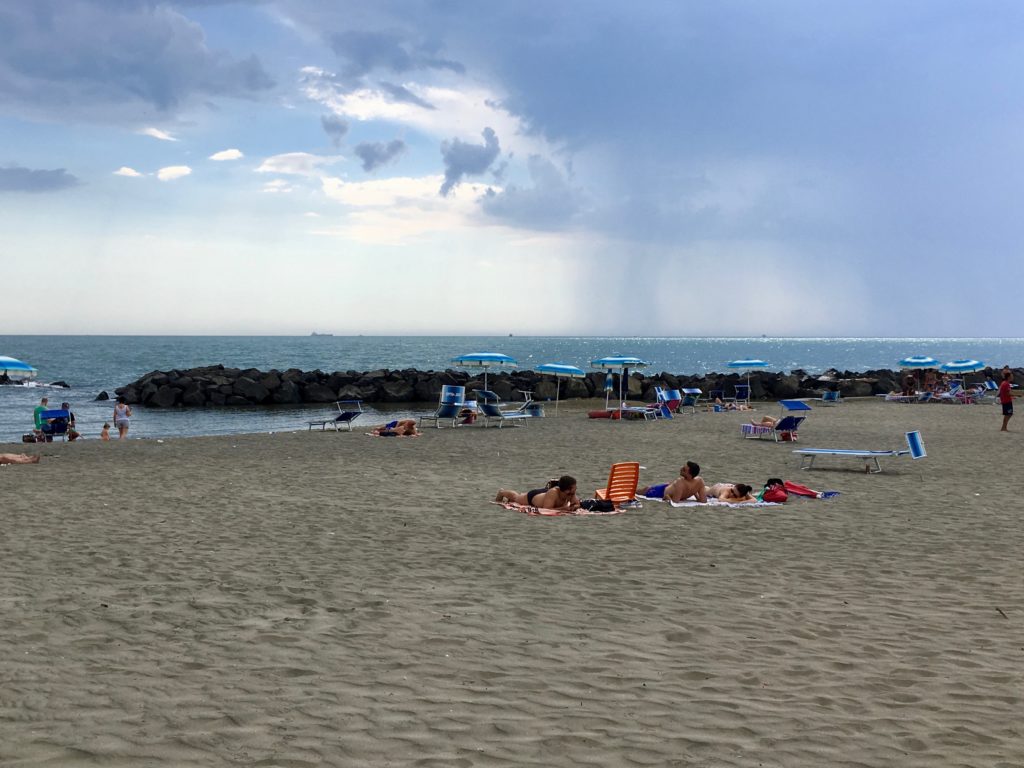 Romans enjoying a bit of sand and sun on the beach in the little fishing port town of Fiumicino.