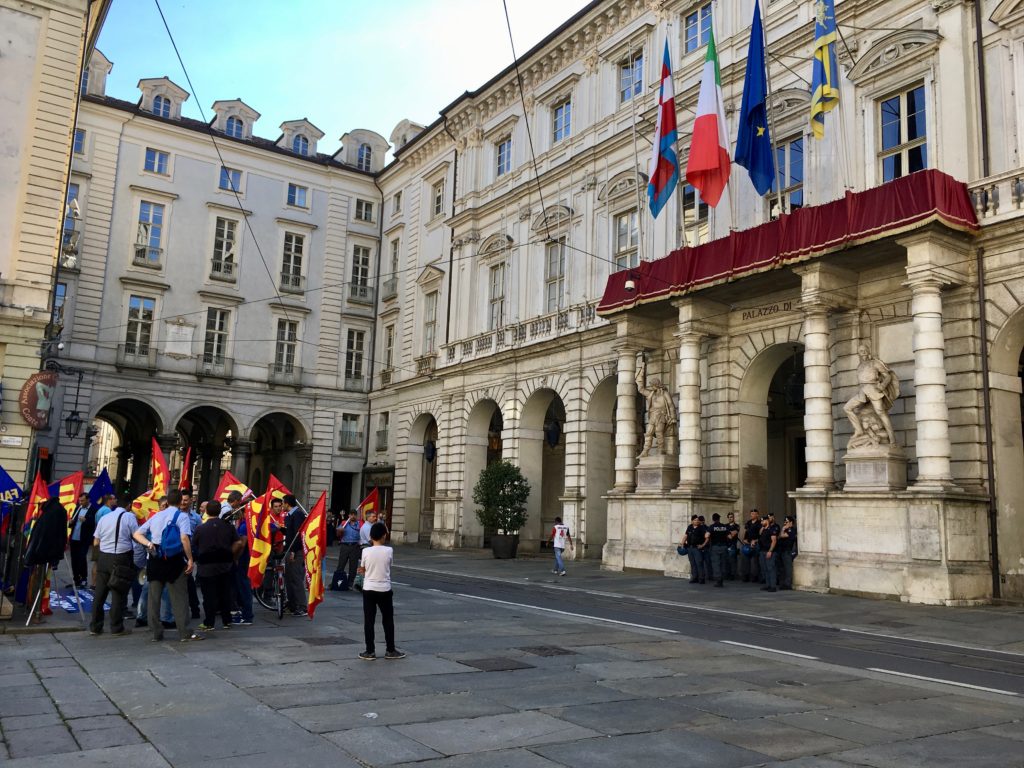 Protesters and police taking up their respective stations at city hall in Turin.