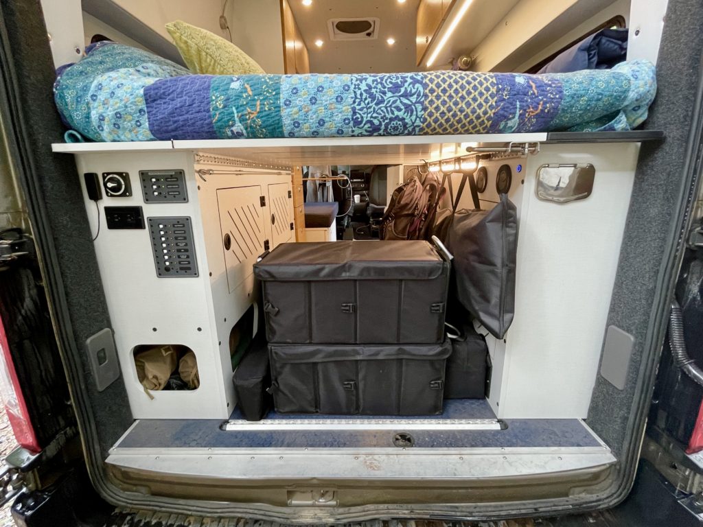 Bed and storage area at the back of the campervan